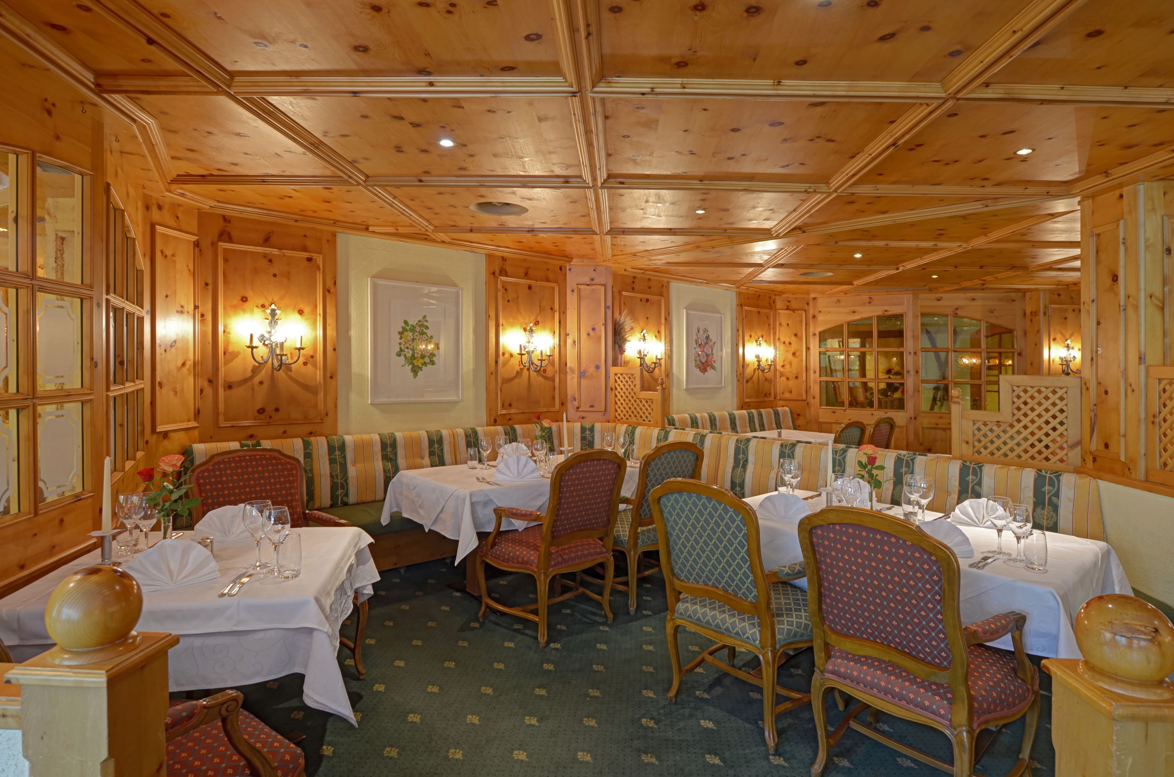 Ein Restaurant mit Holzvertäfelung, mehreren Tischen und Stühlen.