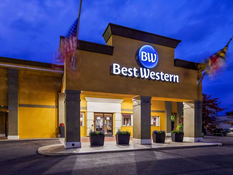 Un hotel Best Western con fachada moderna, entrada con puertas de vidrio y zona de estacionamiento.