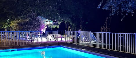 Una piscina al aire libre de temporada, sillones reclinables de piscina