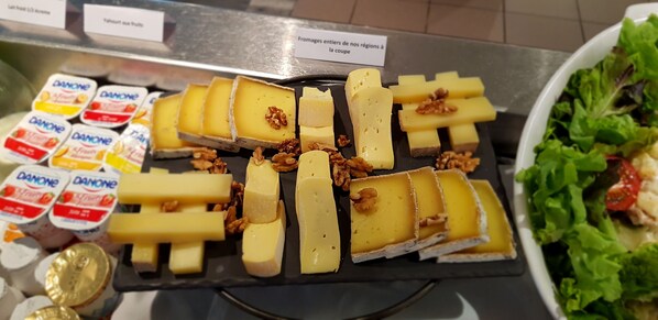 A cheese display with various types of cheese and walnuts.