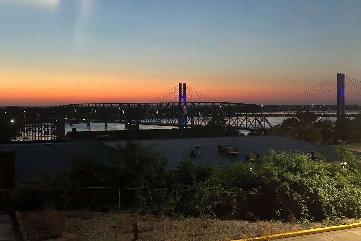 Eine Brücke bei Sonnenuntergang mit freiem Blick auf die Struktur und das darunterliegende Wasser.
