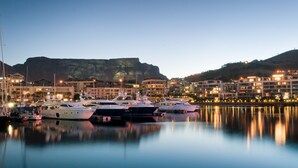 A marina with several yachts docked, surrounded by buildings with balconies overlooking the water. - First Group Riviera Suites (Cape Town)