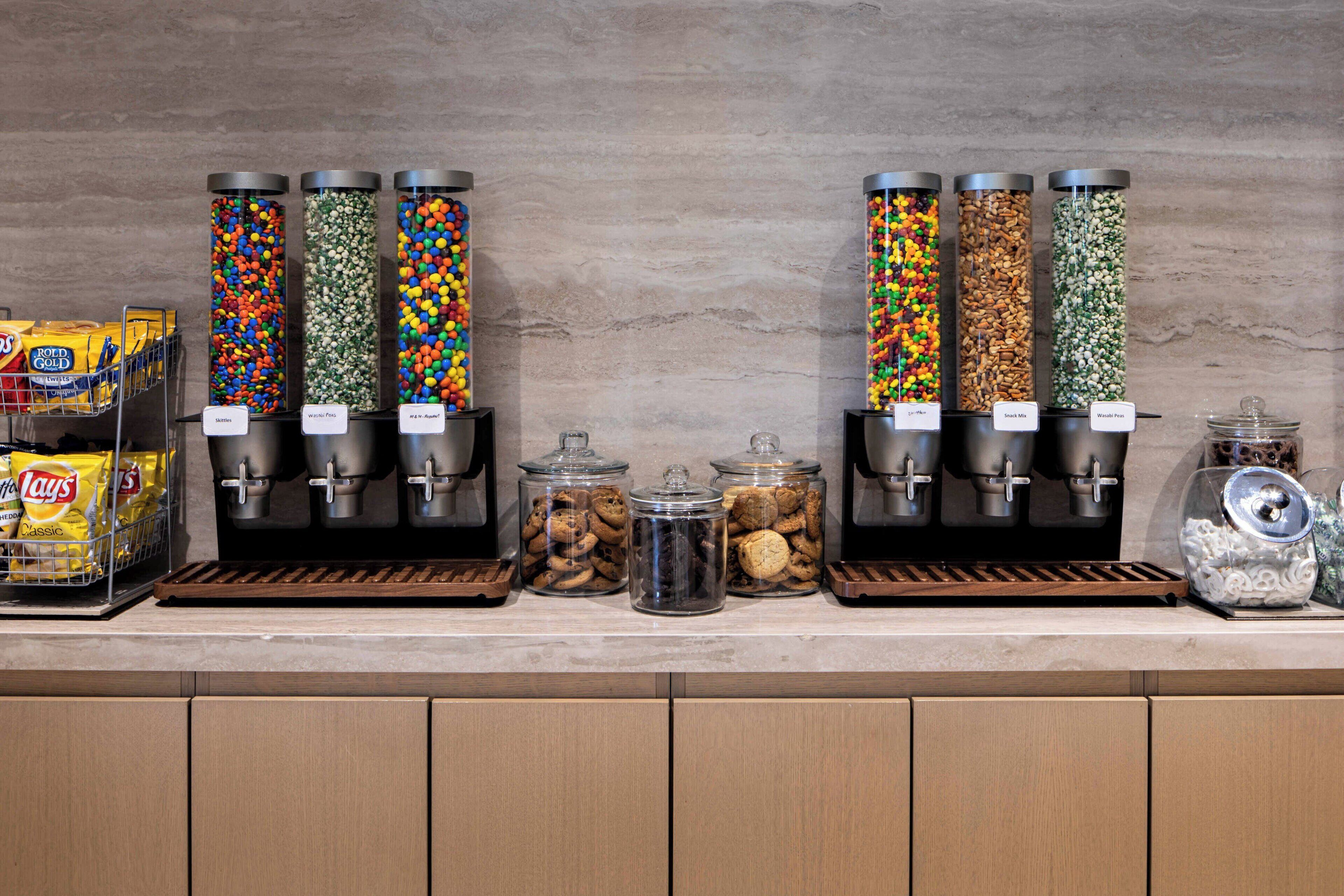 Een snackbar met verschillende bakken vol koekjes, snoep en chips.