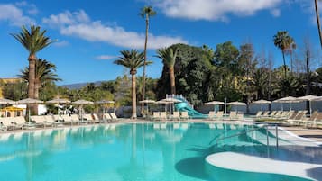 Een buitenzwembad, parasols voor strand/zwembad