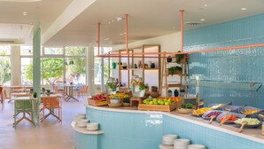 A buffet area with a blue-tiled counter, various fruits, and bowls of food. - Sol Arona Tenerife (Arona)
