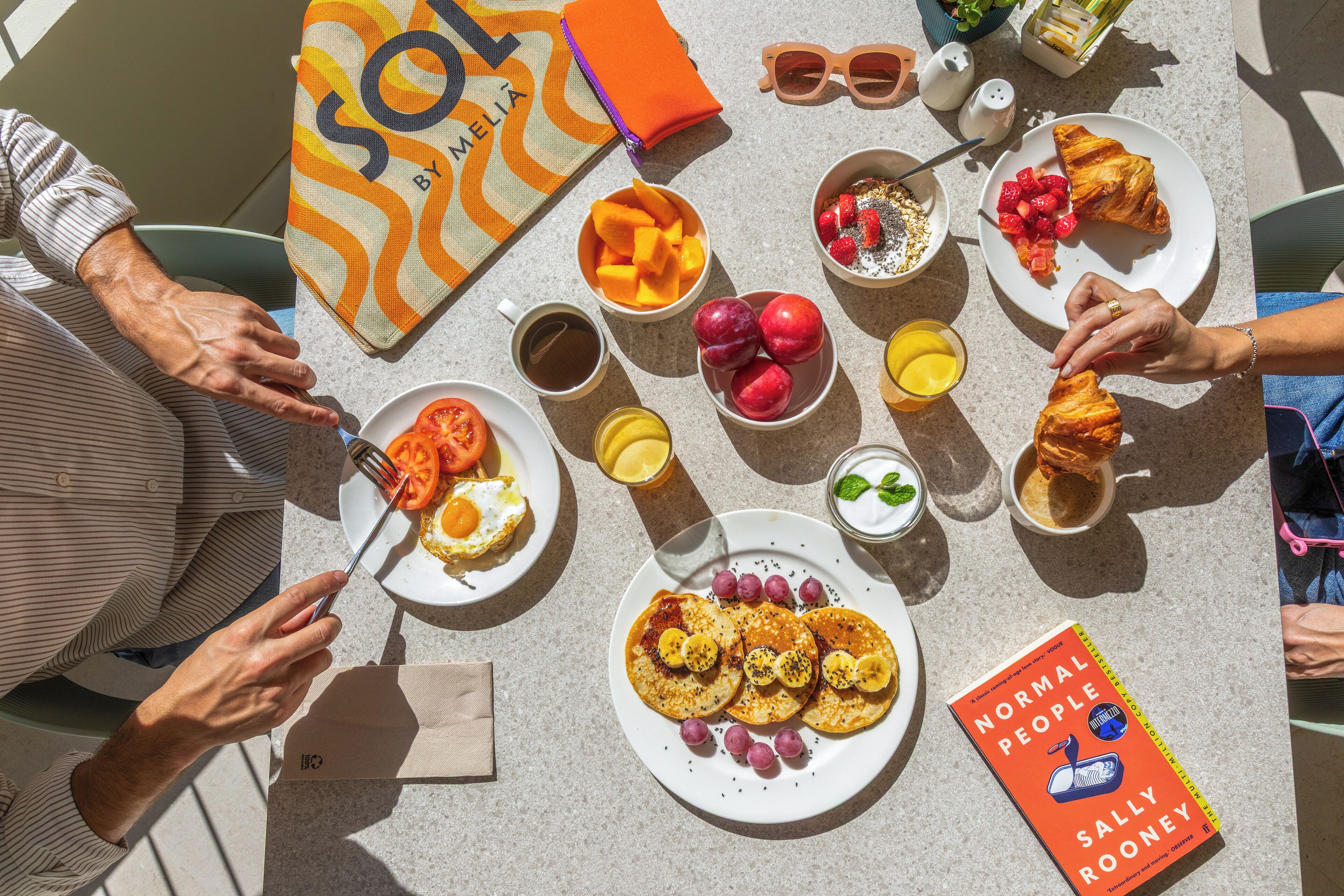 Ein Frühstückstisch mit verschiedenen Speisen und dem Buch 'Normal People' von Sally Rooney.