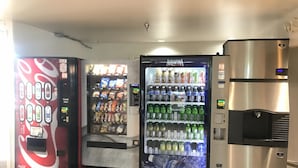 Three beverage vending machines with Coca-Cola, Aquafina, and other brands, and a stainless steel water dispenser. - Motel 6 Raleigh, NC - North (Raleigh)