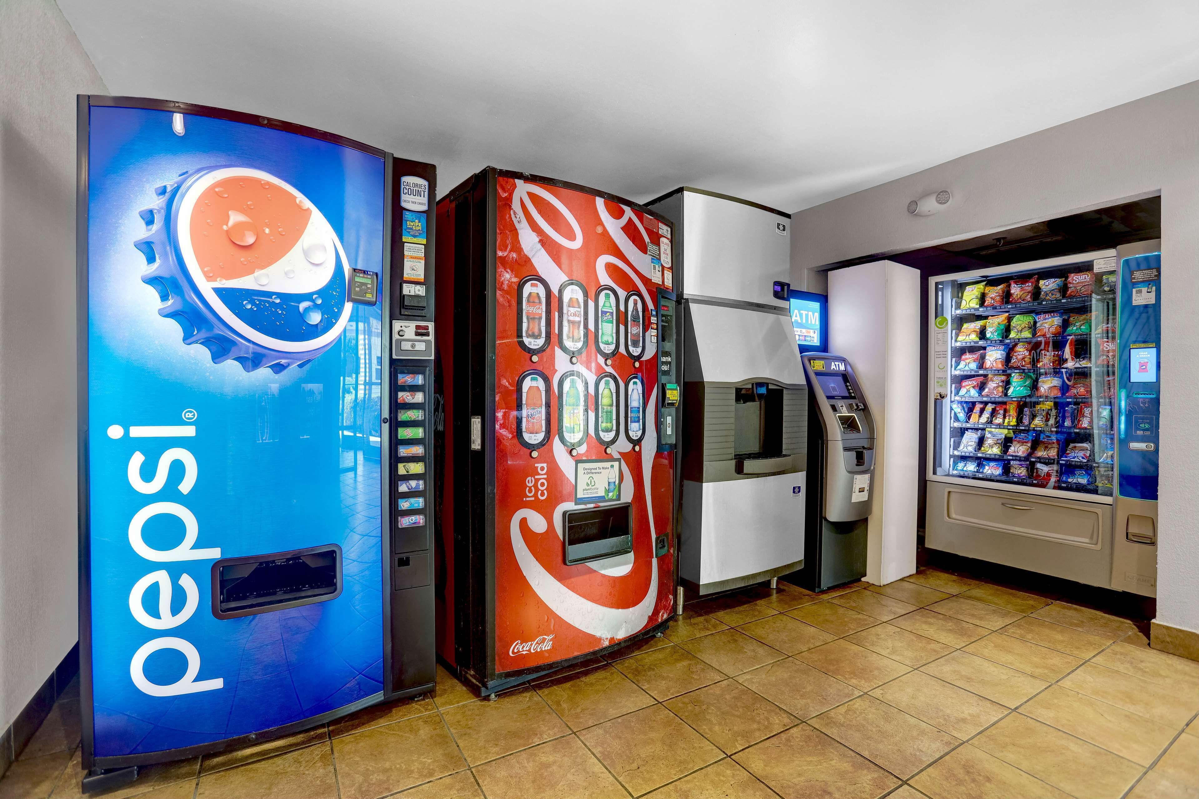 Ein Verkaufsautomatenbereich mit Pepsi- und Coca-Cola-Automaten, einem Geldautomaten und einem Snackautomaten.