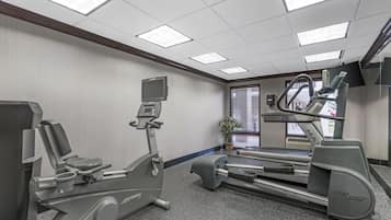 A fitness room with cardio equipment including a stationary bike, elliptical, and treadmill.