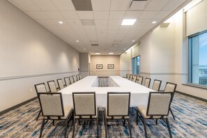 A conference room with a long table, chairs, and a carpeted floor. - Doubletree by Hilton Cedar Rapids Convention Complex (Cedar Rapids)