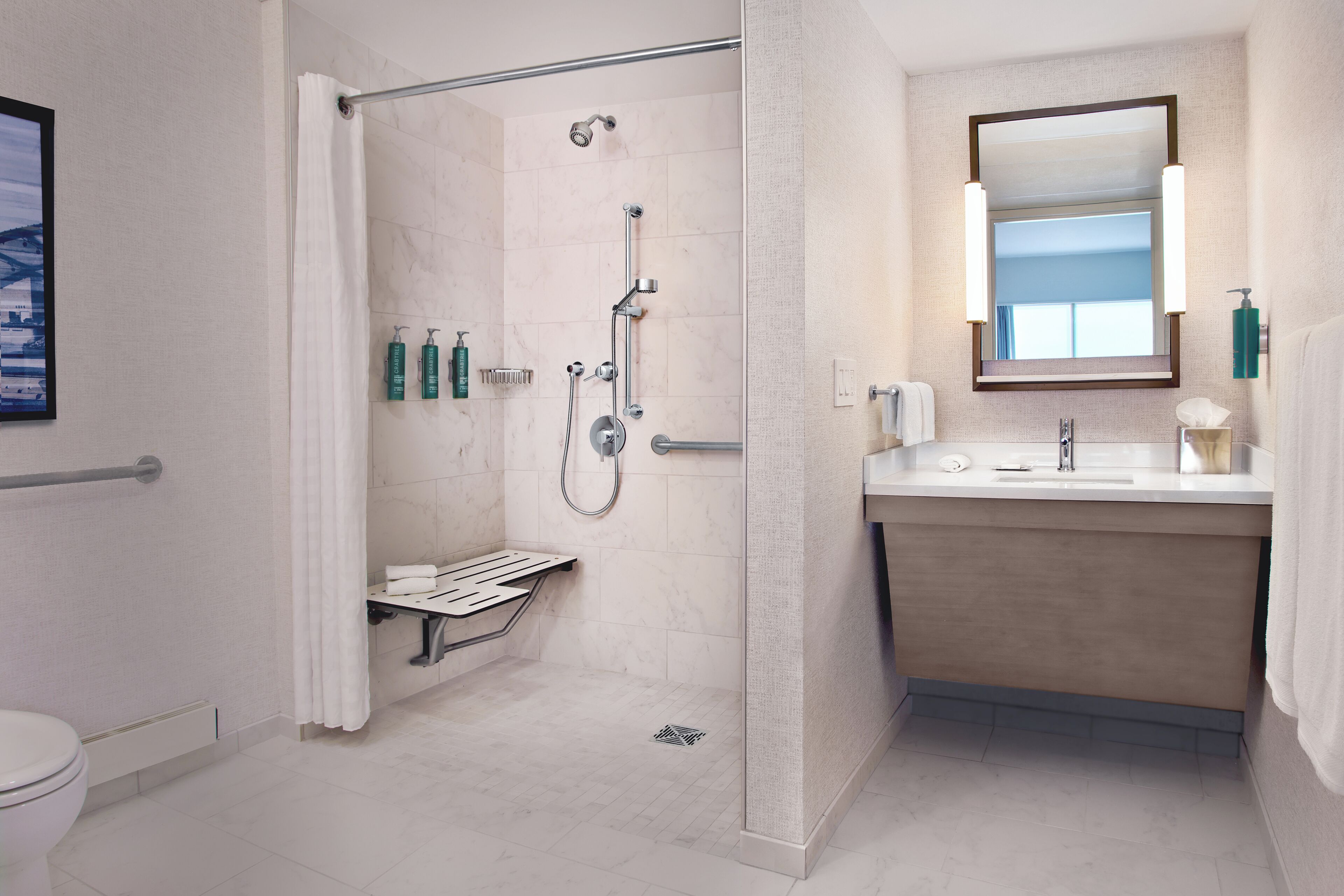 A modern bathroom with a shower, toilet, and sink.