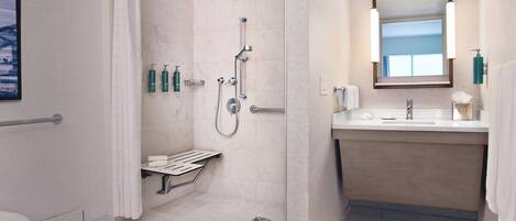 A modern bathroom with a shower, toilet, and sink.