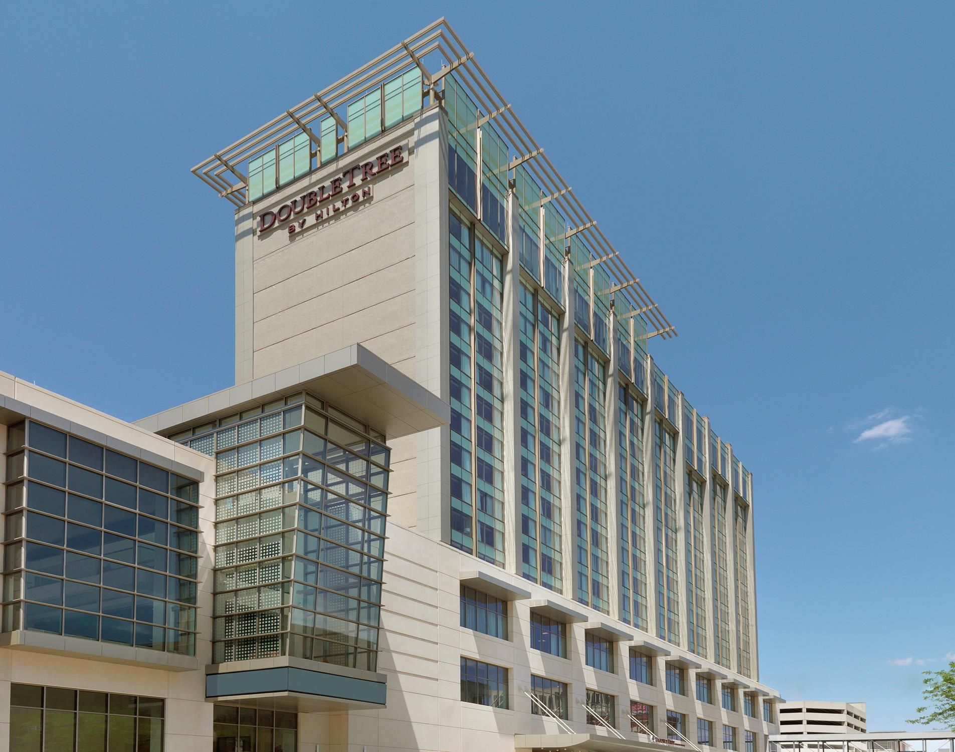 A high-rise hotel with a prominent 'DOUBLETREE' sign, large windows, and a modern architectural design.