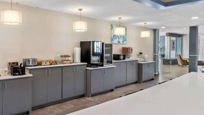 A modern kitchen with grey cabinets, a large island, and a coffee machine. - Best Western Atlanta Cumberland/Galleria Hotel (Smyrna)