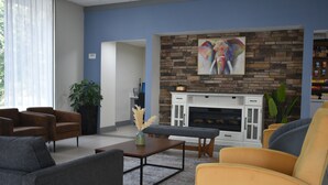 A modern living room with a fireplace, sofas, and a coffee table. - Best Western Atlanta Cumberland/Galleria Hotel (Smyrna)
