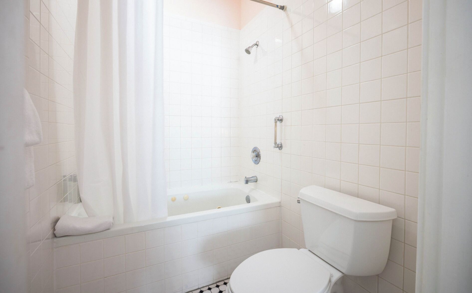 Une salle de bain avec une baignoire, des toilettes et un rideau de douche.