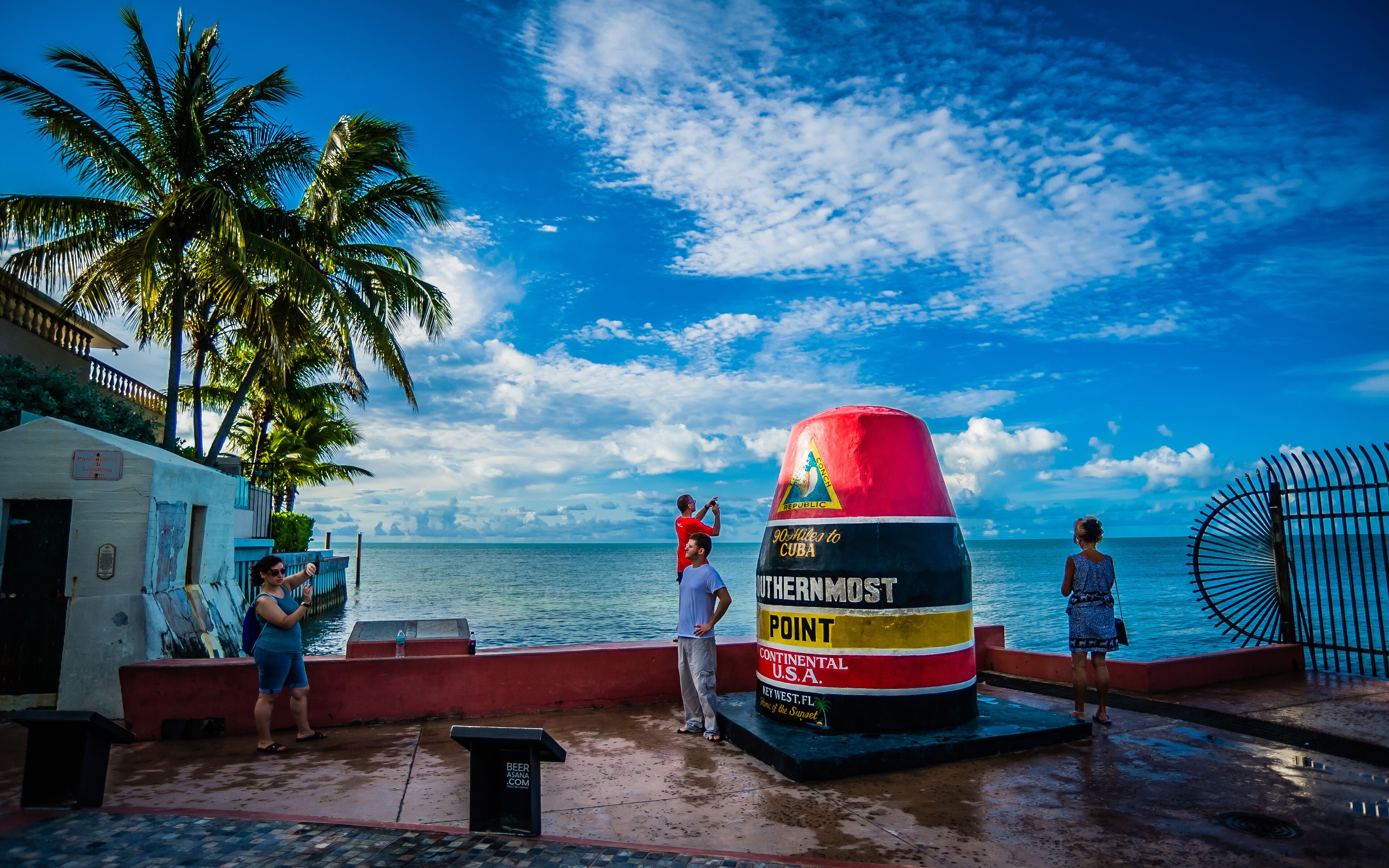 A beachside location with a large colorful marker labeled "90 Miles to Cuba" and "Continental U.S.A."