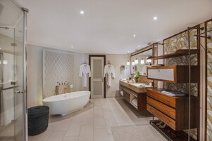 Ein modernes Badezimmer mit einer freistehenden Badewanne, einem Waschtisch mit Spiegel und einem großen Spiegel über dem Waschtisch.