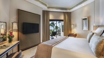 A hotel room with a large bed, a desk with a chair, a television, and a view of the outdoors.
