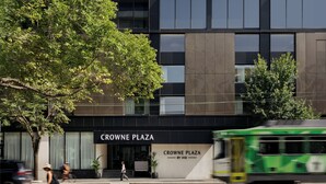 Un edifici modern amb un rètol que diu 'CROWNE PLAZA BY IHG'.