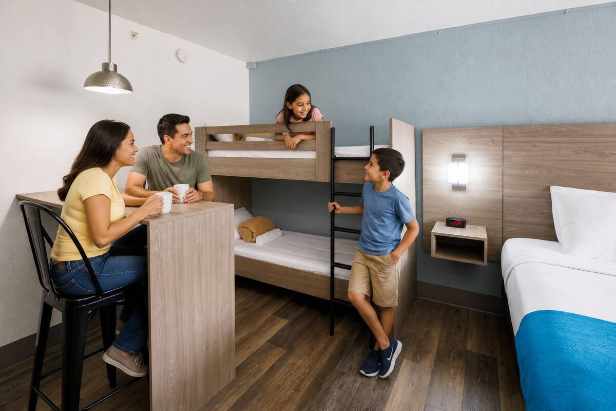 Quarto com beliche, escrivaninha e cama.
