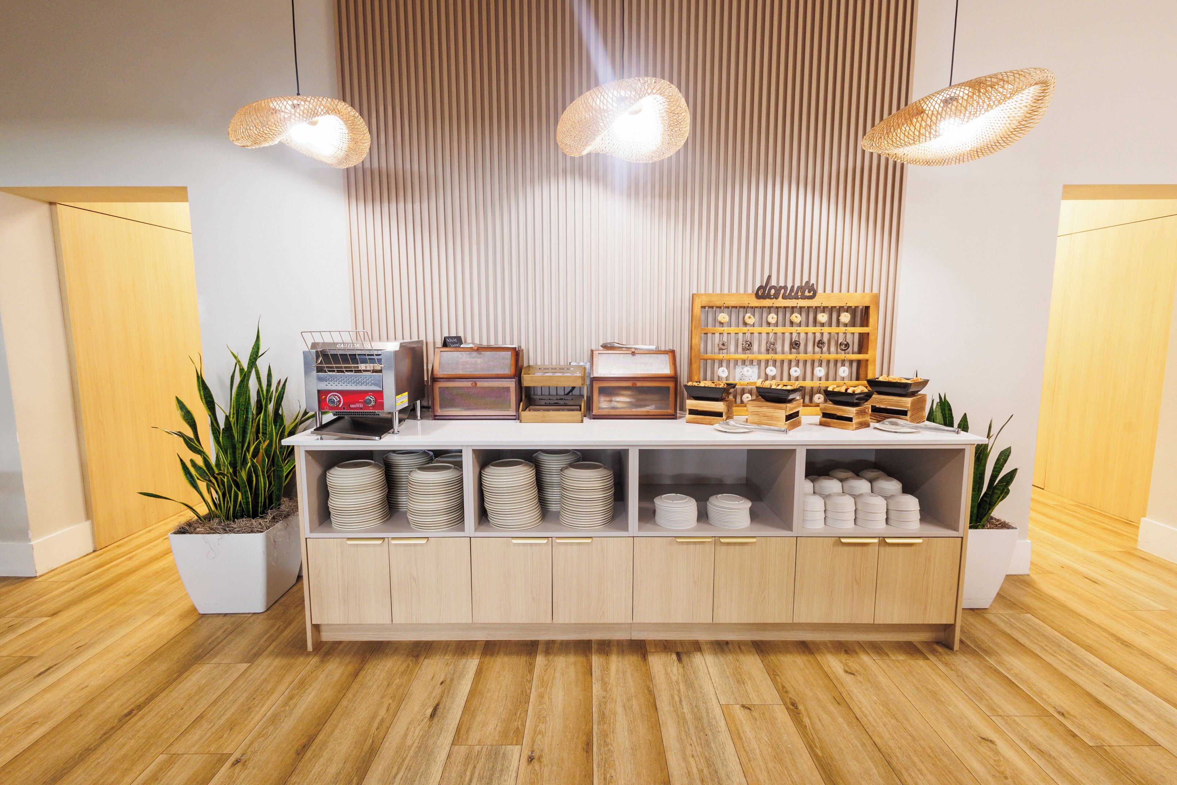Un espace d’accueil avec un comptoir en bois, une machine à café et un présentoir de collations.