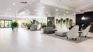 A spacious lobby with modern furniture, a reception desk, and indoor plants. - Coco Key Hotel & Water Park Resort (Orlando)