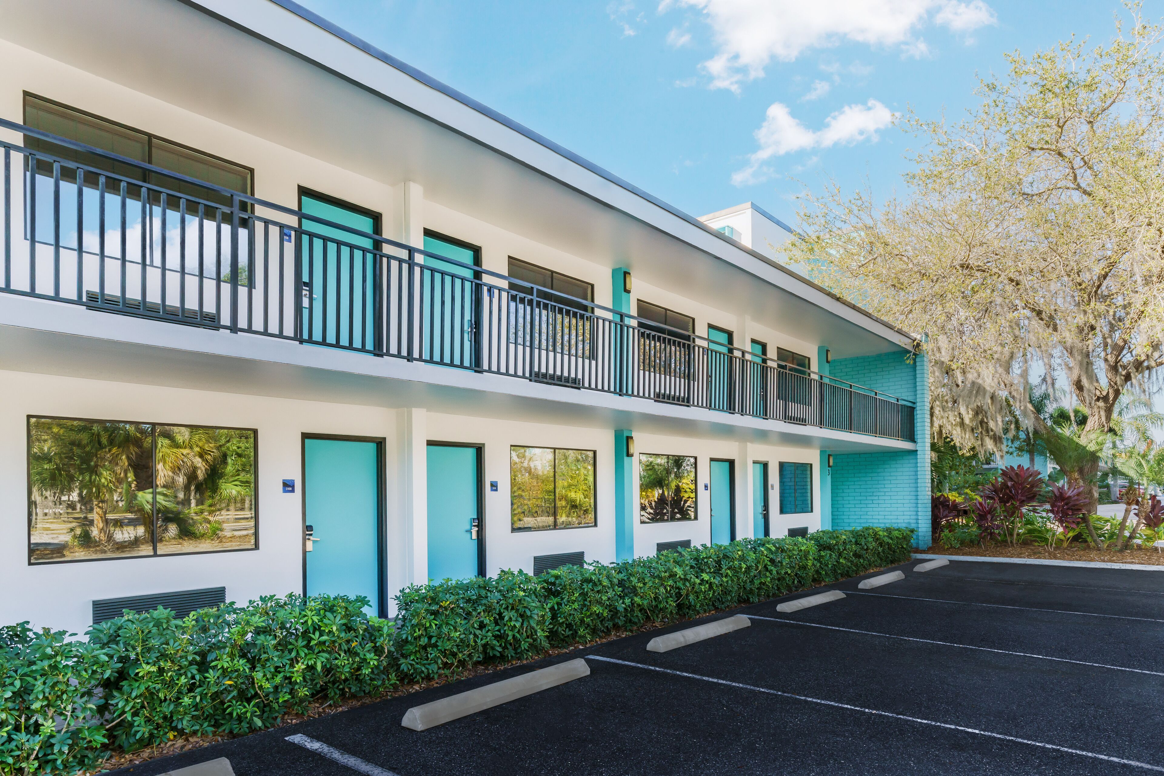 Un motel à deux étages, avec une rangée de chambres au rez-de-chaussée et un balcon à l’étage supérieur.