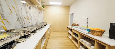 A buffet setup with various food stations, wooden shelving, and a marble wall.