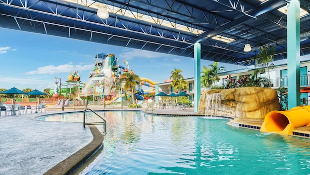 A large indoor pool with a water slide and a rock formation. - Coco Key Hotel & Water Park Resort (Orlando)
