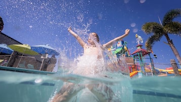 A person swimming in a pool with water splashing around.