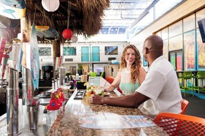 A bar area with a counter, drinks, and a menu.