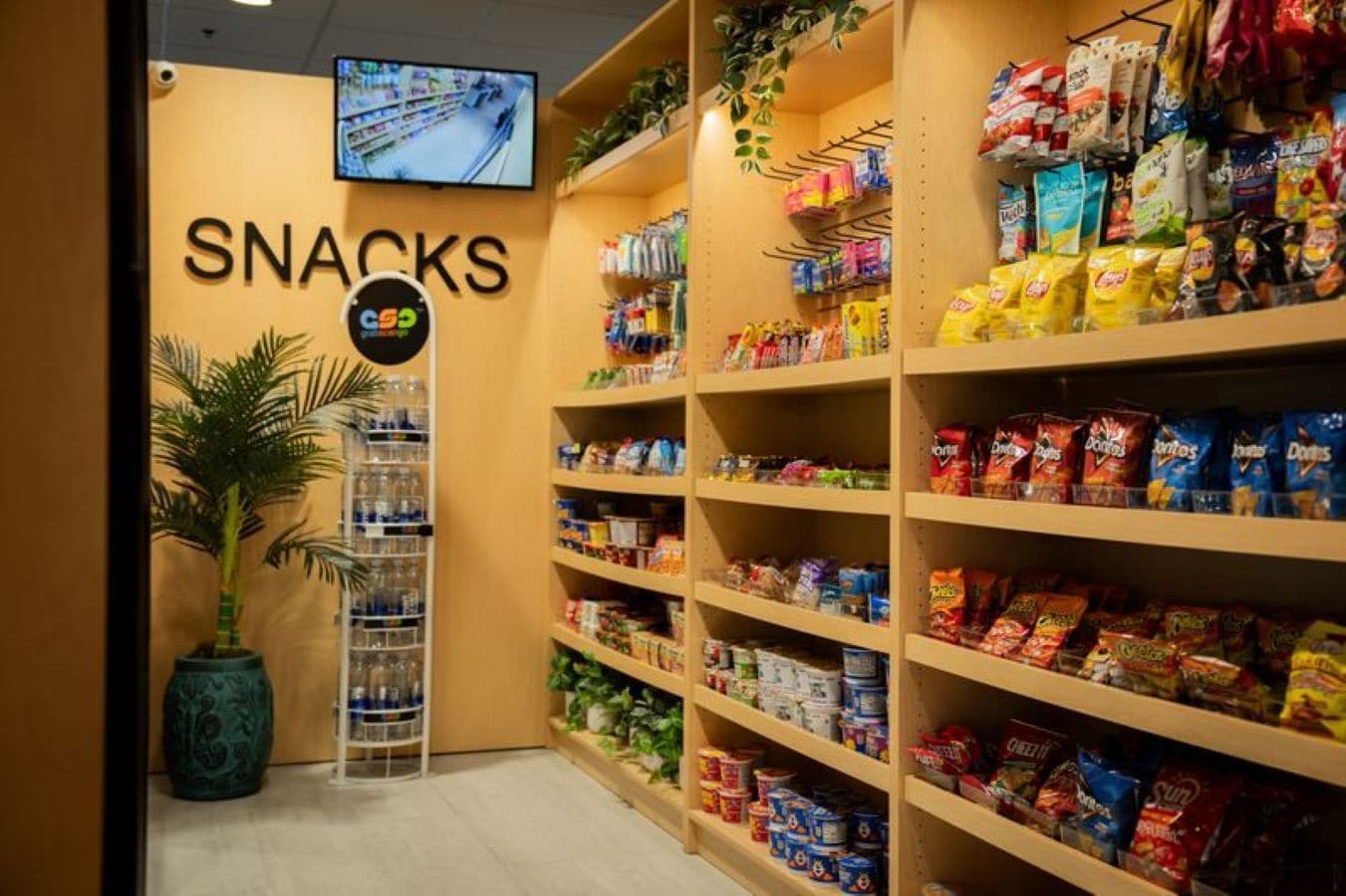 En hylla med snacks, där hyllorna är fyllda med olika sorters chips och andra snacks.