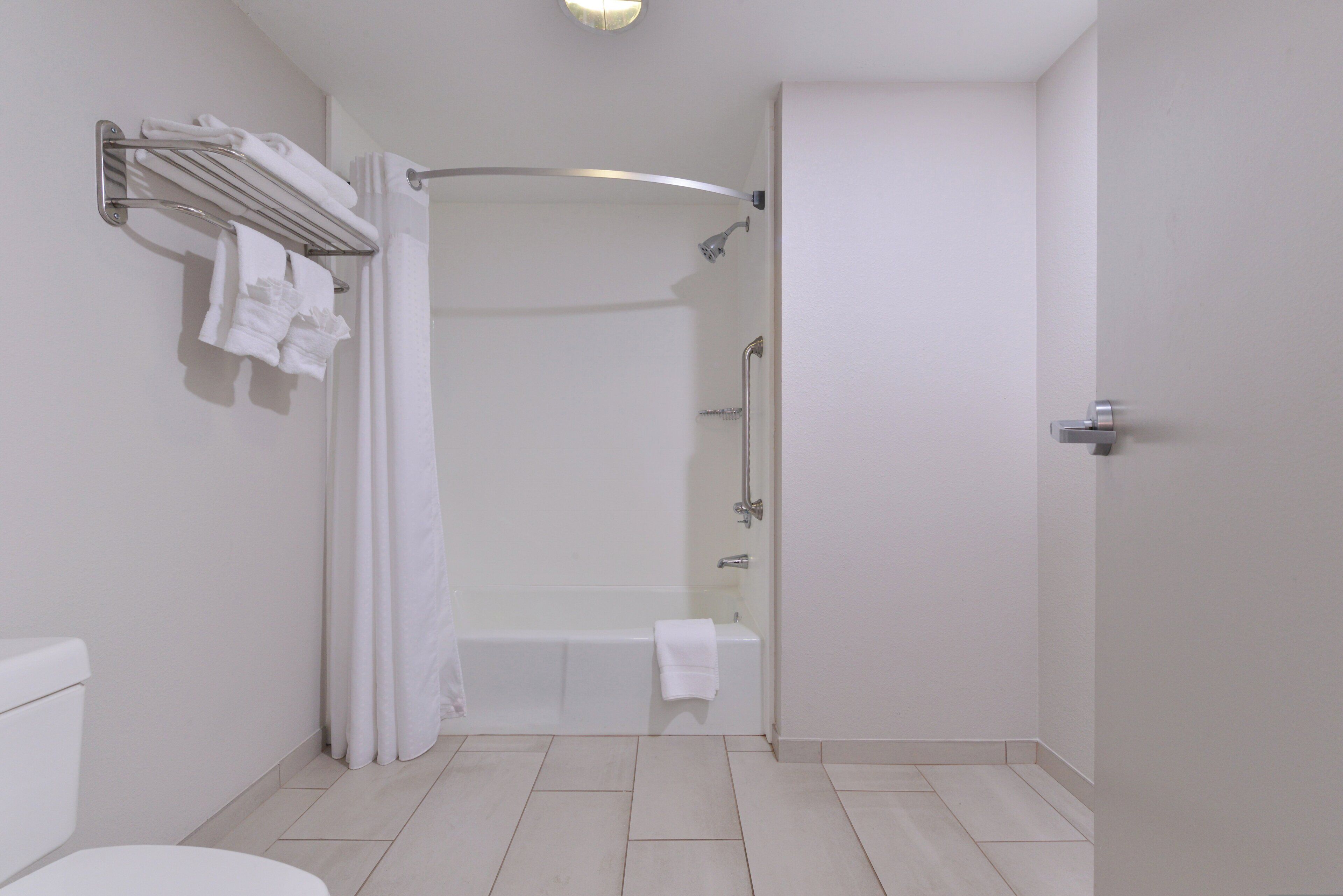 Un baño moderno con ducha, inodoro y barra para toallas.