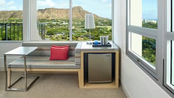 Een moderne kamer met een bank, een kleine tafel, een lamp en een minibar.