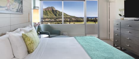 A hotel room with a bed, a chair, a dresser, and a TV.