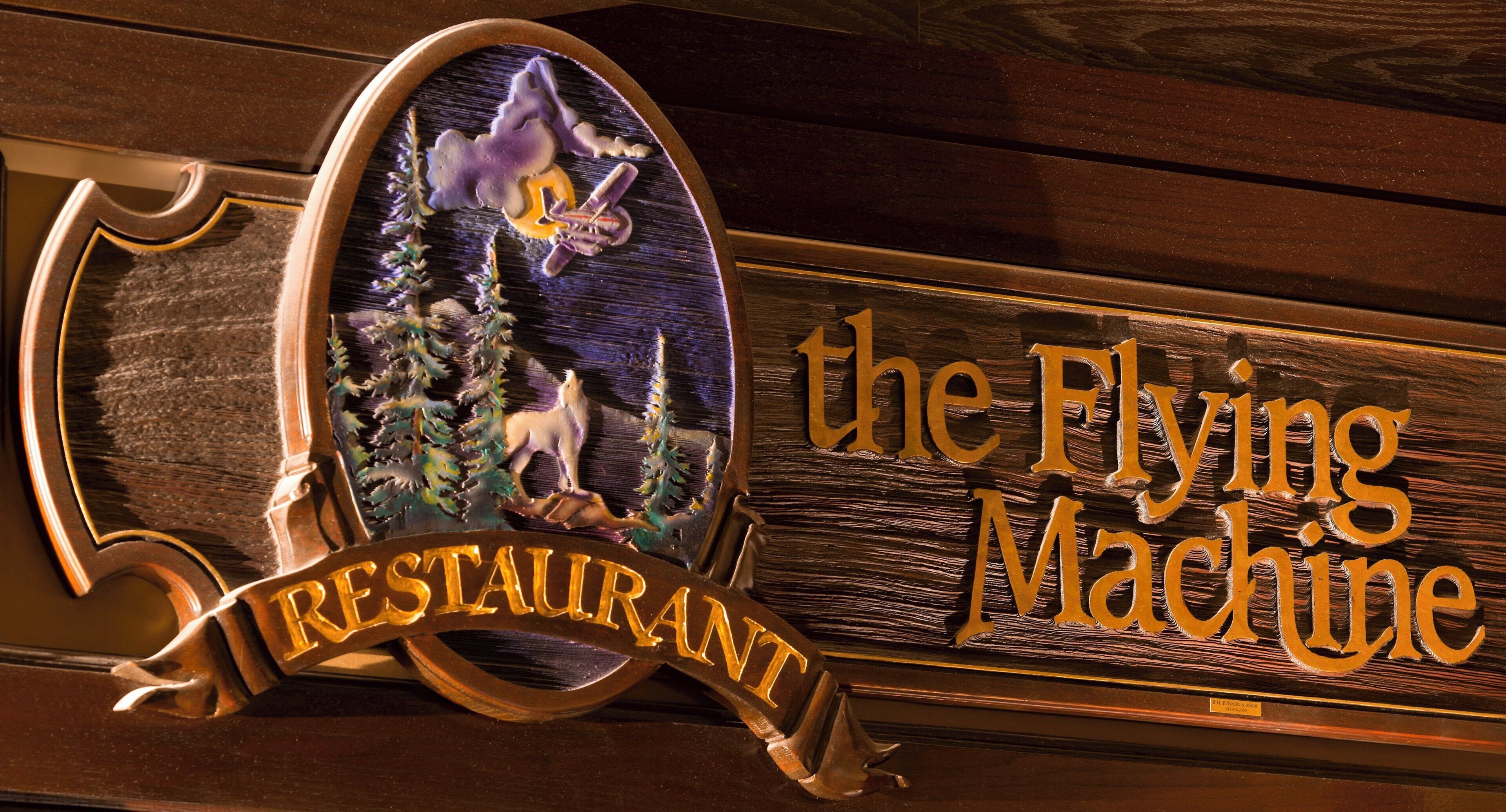 Un letrero de madera con un logotipo y el texto 'the Flying Machine Restaurant'.
