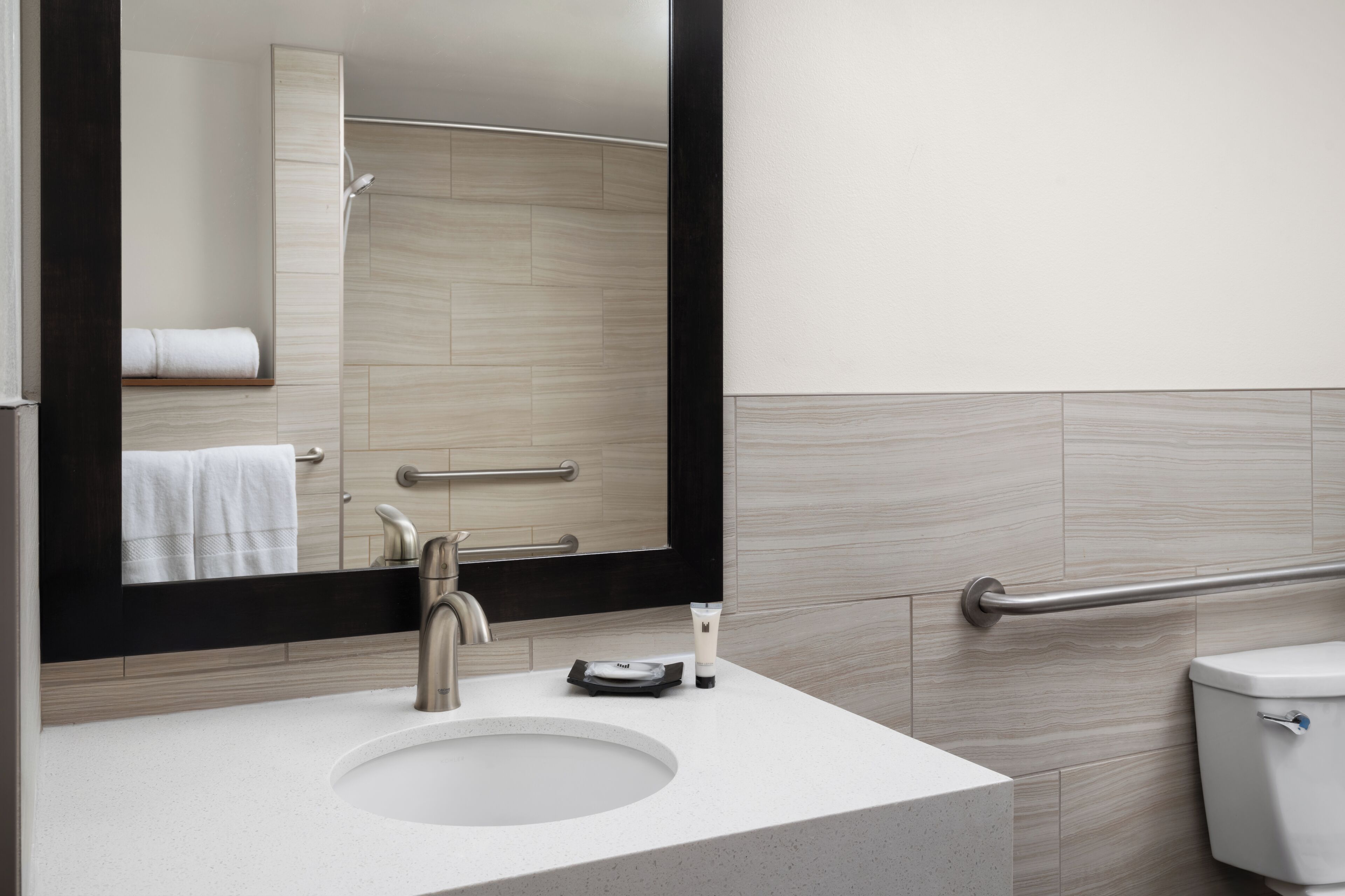 Un bagno moderno con lavandino, specchio e WC.