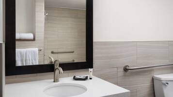 Un bagno moderno con lavandino, specchio e WC.