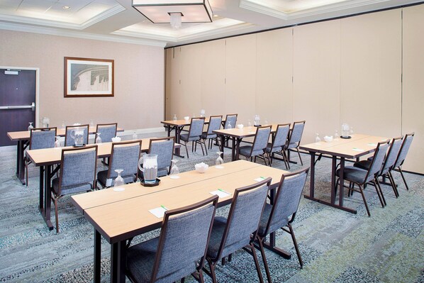 A conference room with multiple tables and chairs, equipped with water bottles and glasses. - Courtyard By Marriott Ann Arbor (Ann Arbor)