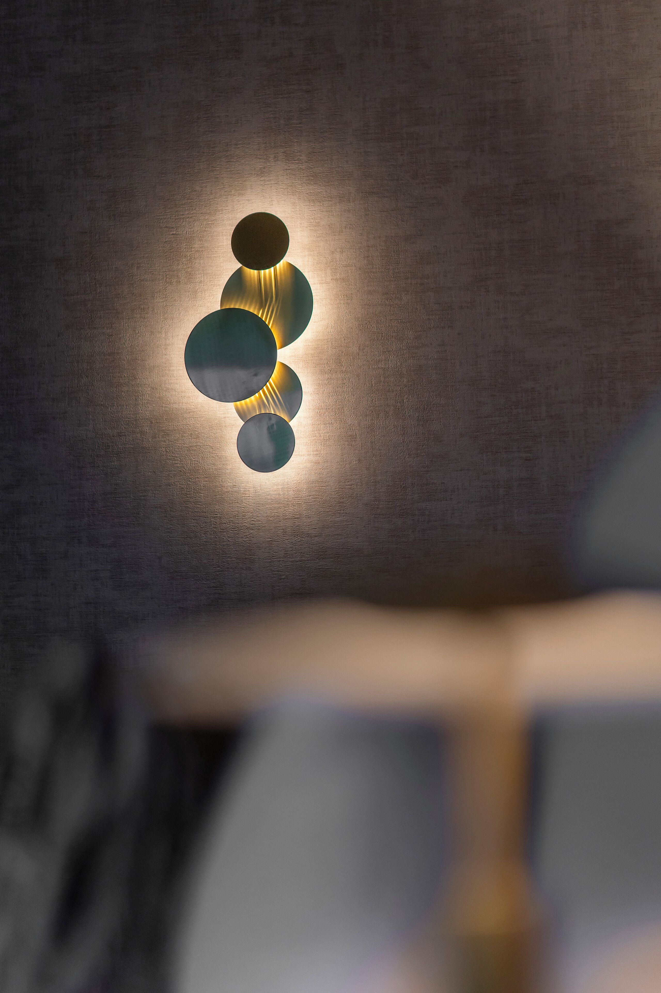 A wall-mounted light fixture with three circular elements.