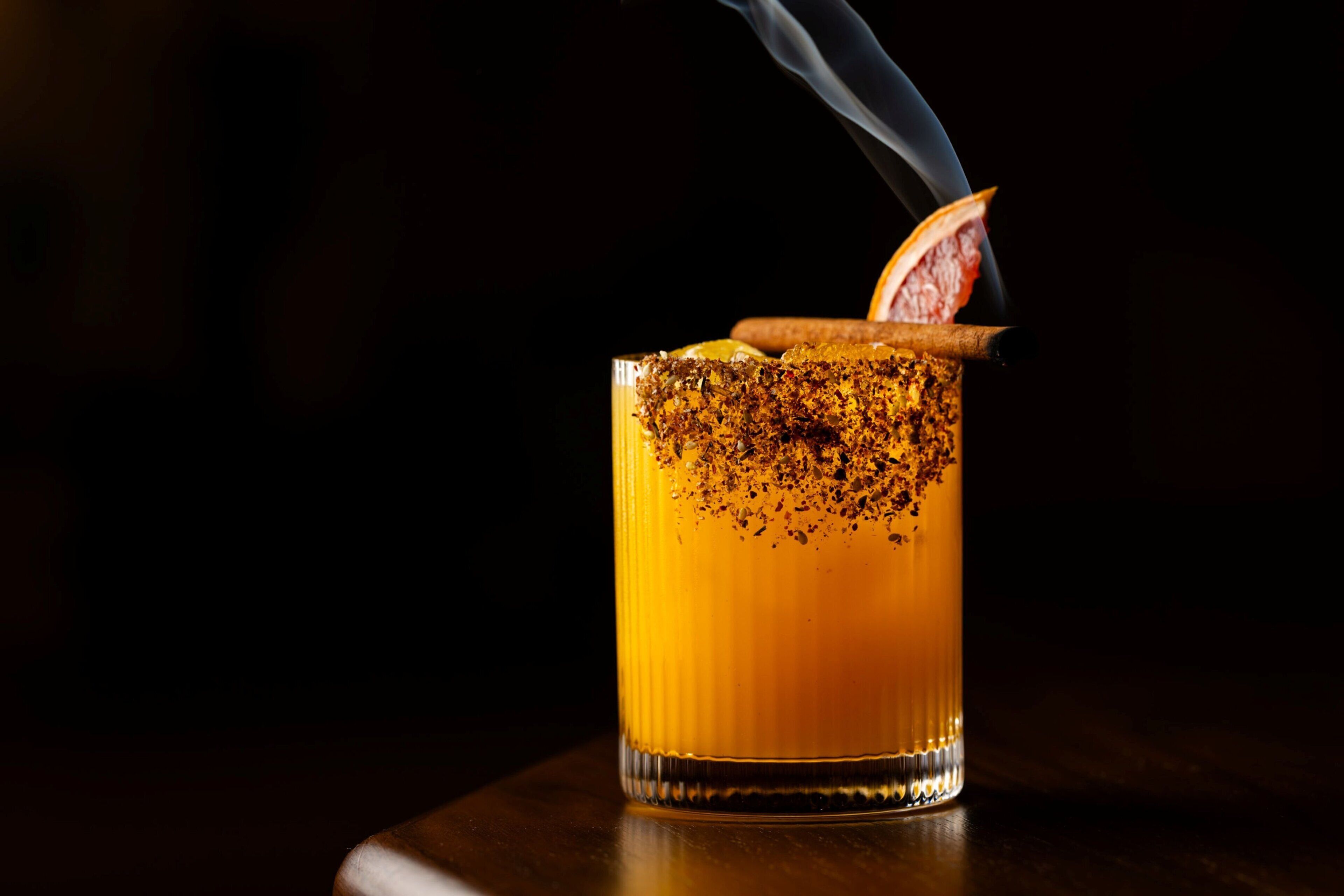 A cocktail glass with a dark background.