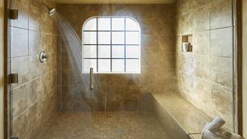 Bathroom features a shower area with a glass door and rain showerhead, and a bathtub adjacent to a window.