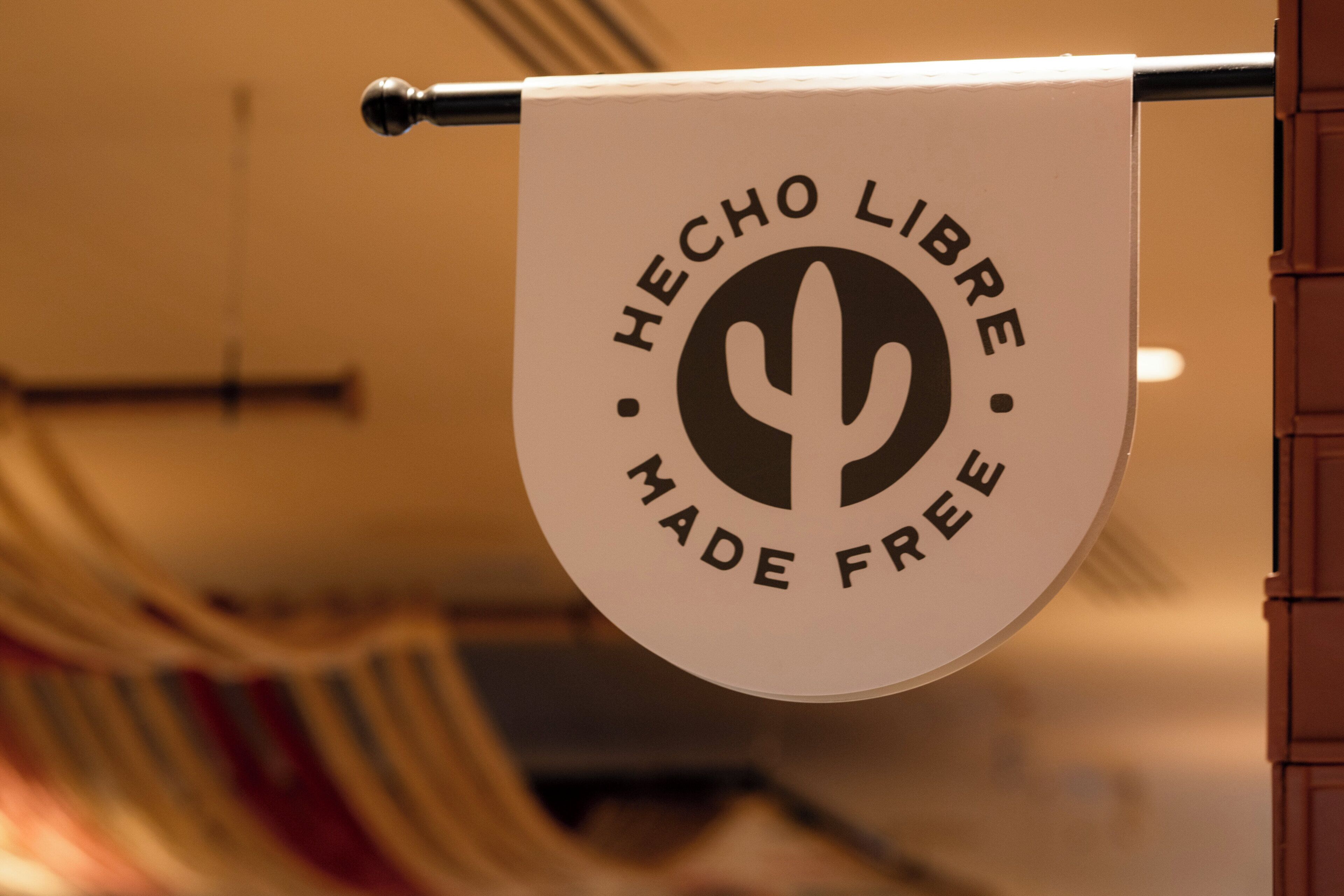 Une bannière avec le texte « HECHO LIBRE MADE FREE » et un symbole représentant un cactus.