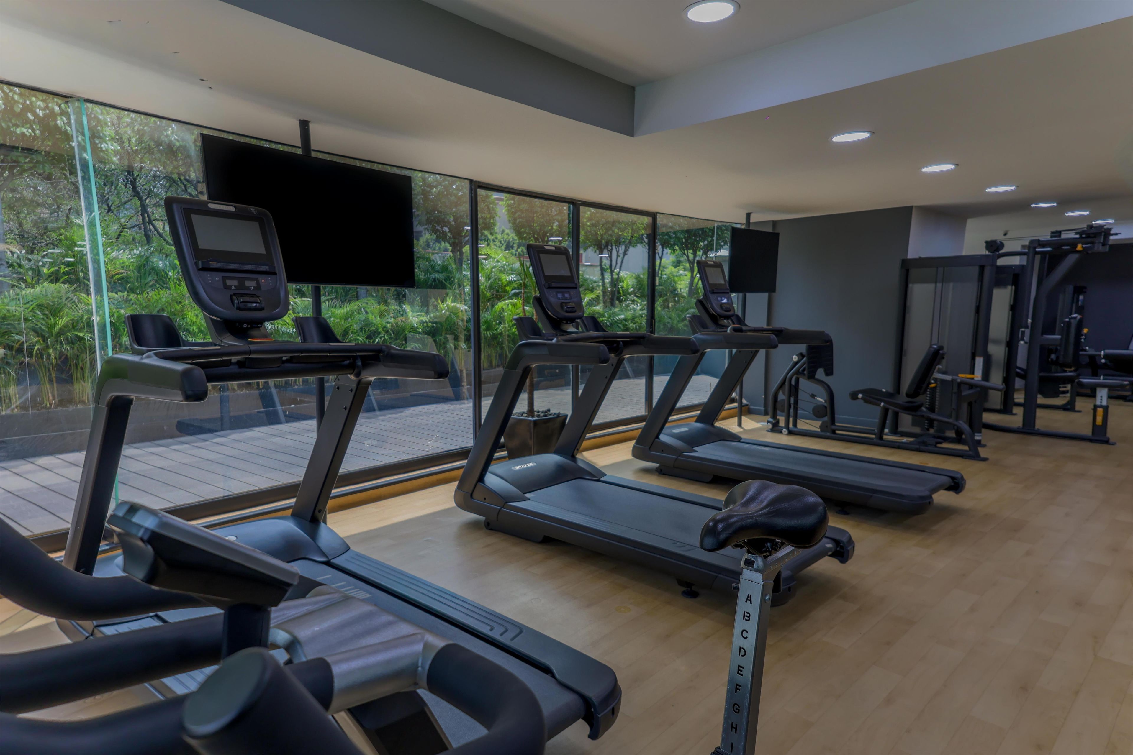 Ein Fitnessstudio mit Laufbändern, Ergometer und Kraftgeräten.