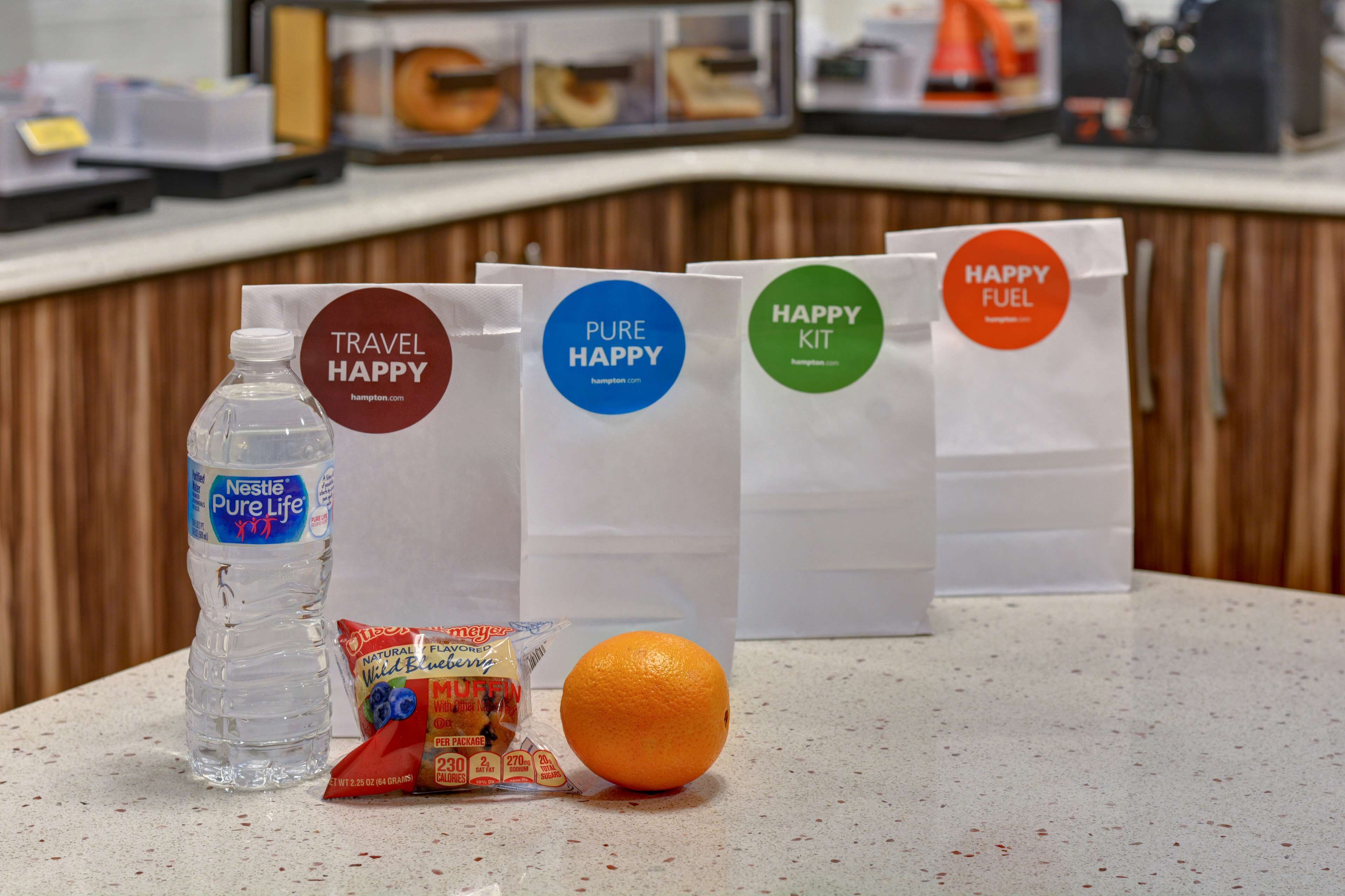 A counter with travel bags, a water bottle, and a snack packet.