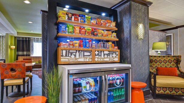 Un présentoir proposant divers en-cas emballés et un distributeur automatique de boissons dans le hall d’un hôtel.
