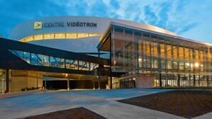 Un bâtiment moderne à la façade incurvée et aux grandes fenêtres en verre, portant l’inscription « CENTRE VIDÉOTRON ».