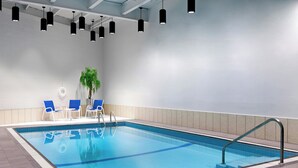 A swimming pool with blue tiles, black pendant lights, and blue chairs. - Four Points by Sheraton Edmundston Hotel & Conference Center (Edmundston)