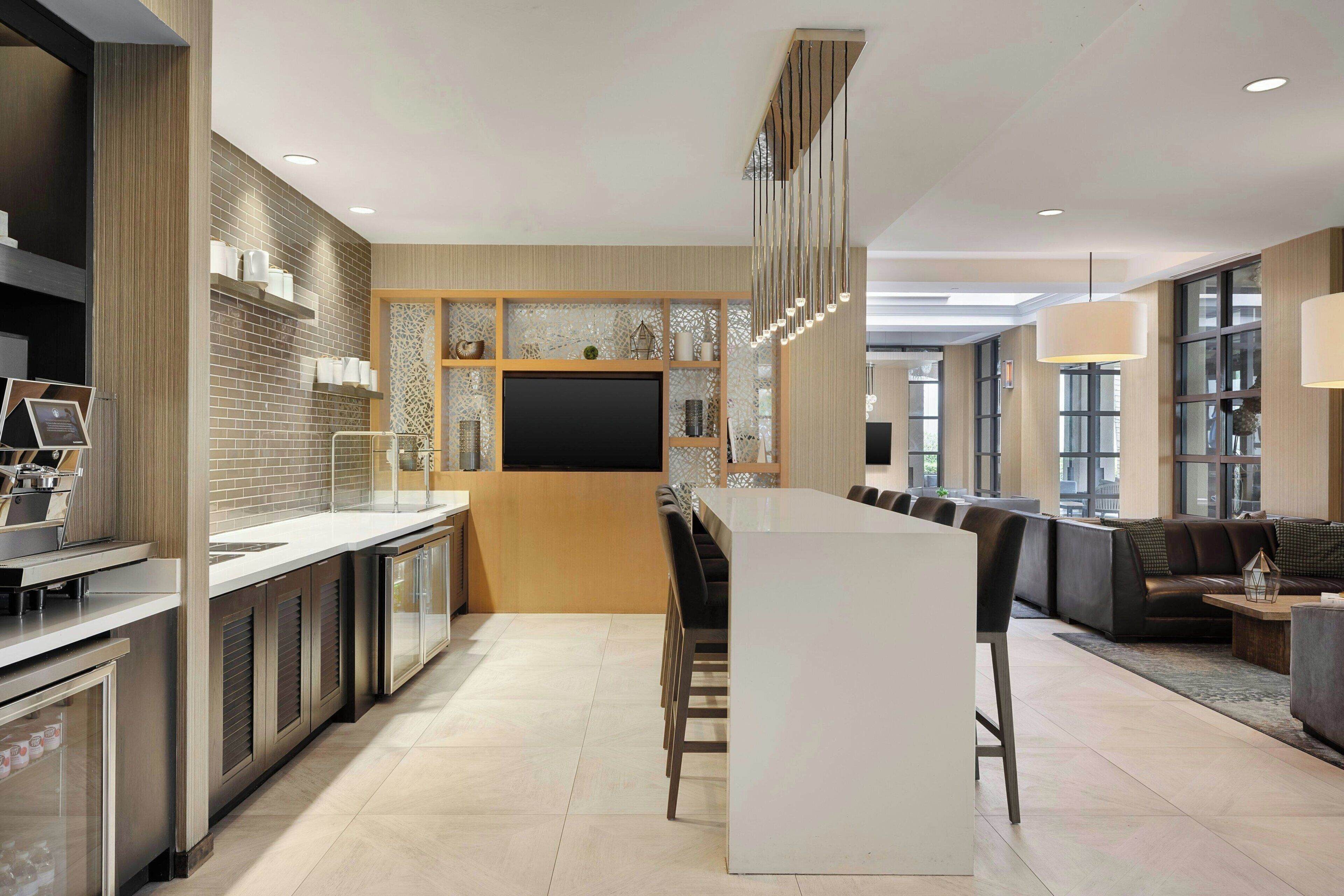 A modern kitchen with a central island, built-in appliances, and a large flat-screen TV.